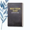 A 6" x 9" notebook with a black chalkboard-style cover featuring the bold phrase "Best Team Ever (Let's Do This)" in yellow text.