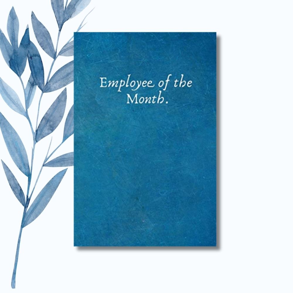 A notebook with the phrase "Employee of the Month" on a glossy cover, perfect for workplace recognition.