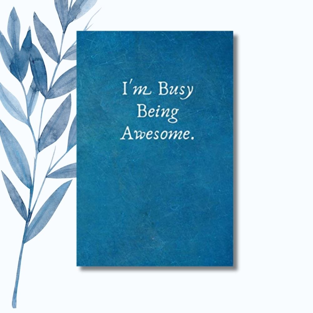 A notebook featuring the phrase "I'm Busy Being Awesome" on a sleek, glossy cover.