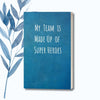 A notebook featuring the phrase "My Team Is Made Up of Super Heroes" on a glossy, bold cover.