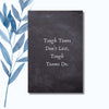 A notebook with the phrase "Tough Times Don’t Last, Tough Teams Do" on a black chalkboard-style cover.