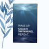 A notebook featuring the phrase "Wake Up. Coach Swimming. Repeat." on a sleek, glossy cover.